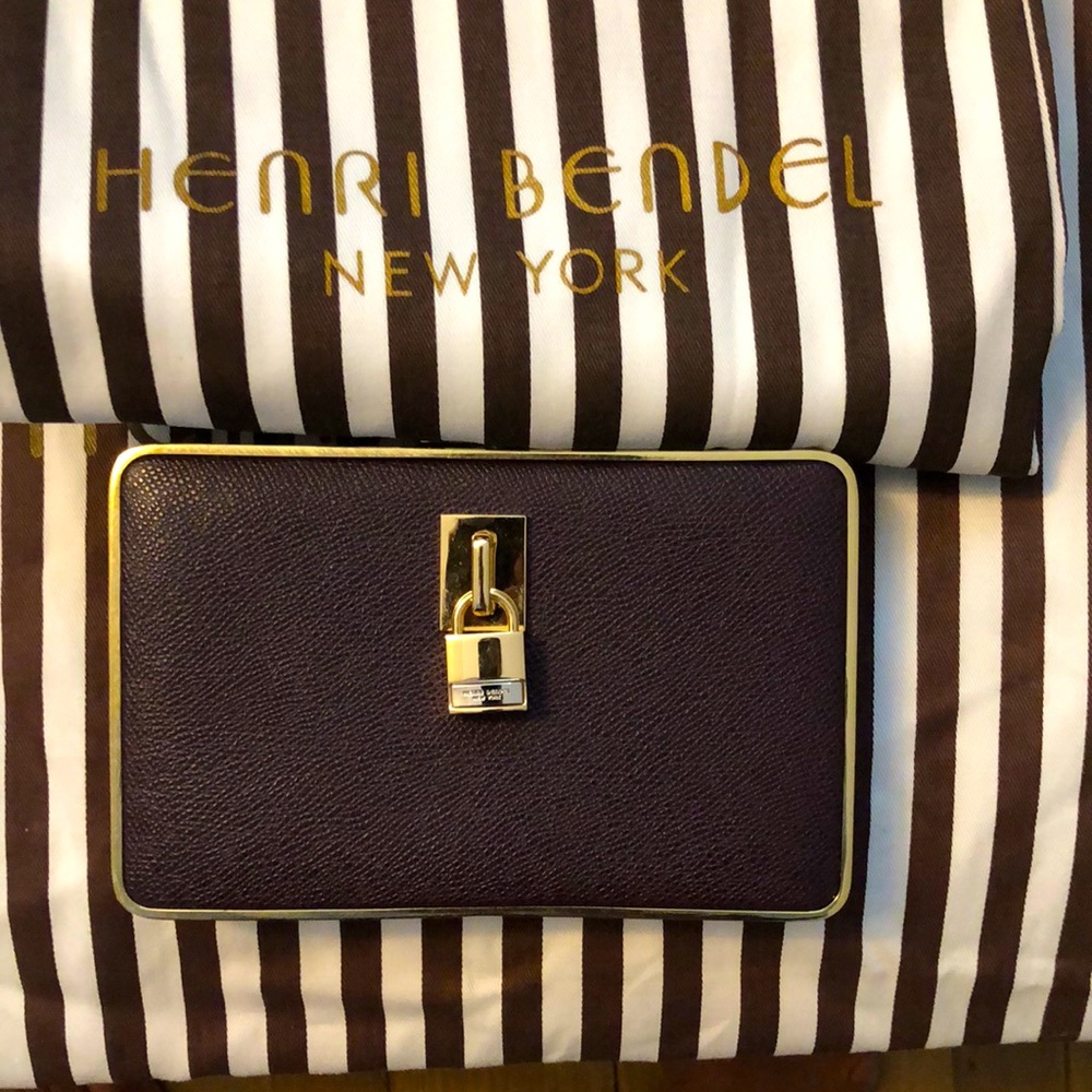 Understated glam Henri Bendel leather clutch with gold hardware and chain strap